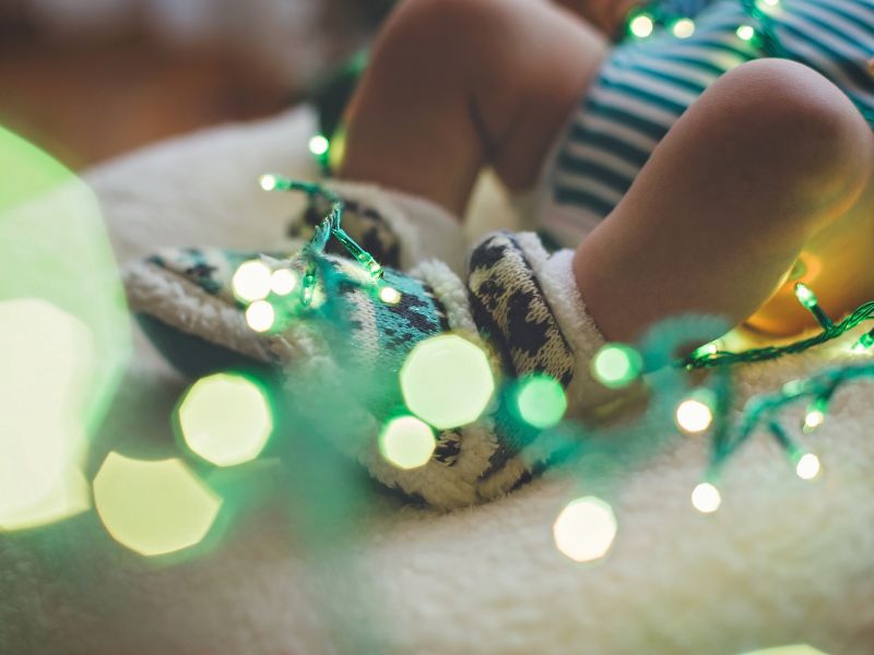 baby's feet wrapped in christmas lights