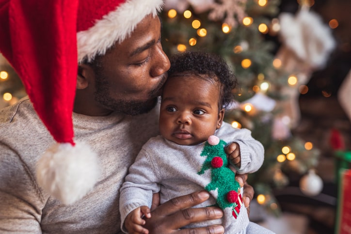 baby with dad in front of christmas tree